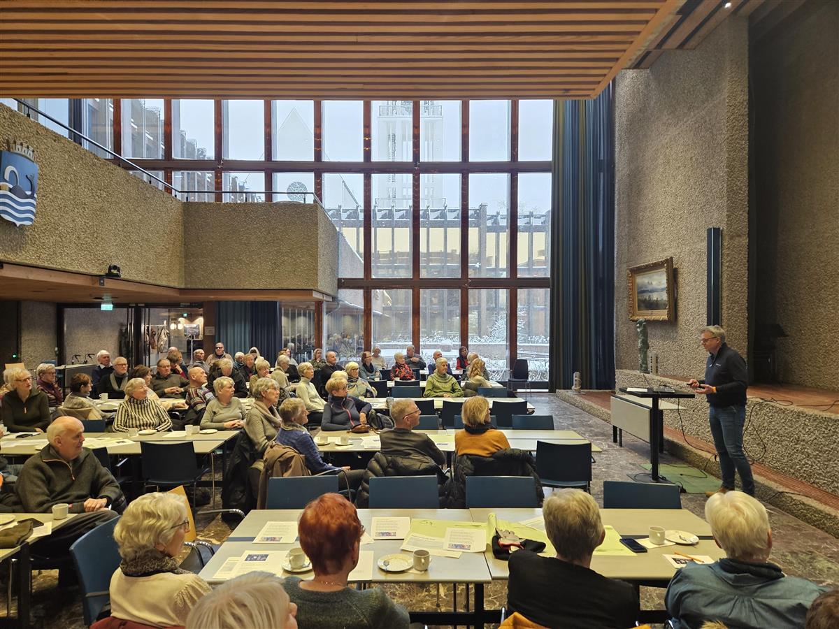 Mann taler foran et rom med seniorer. - Klikk for stort bilde